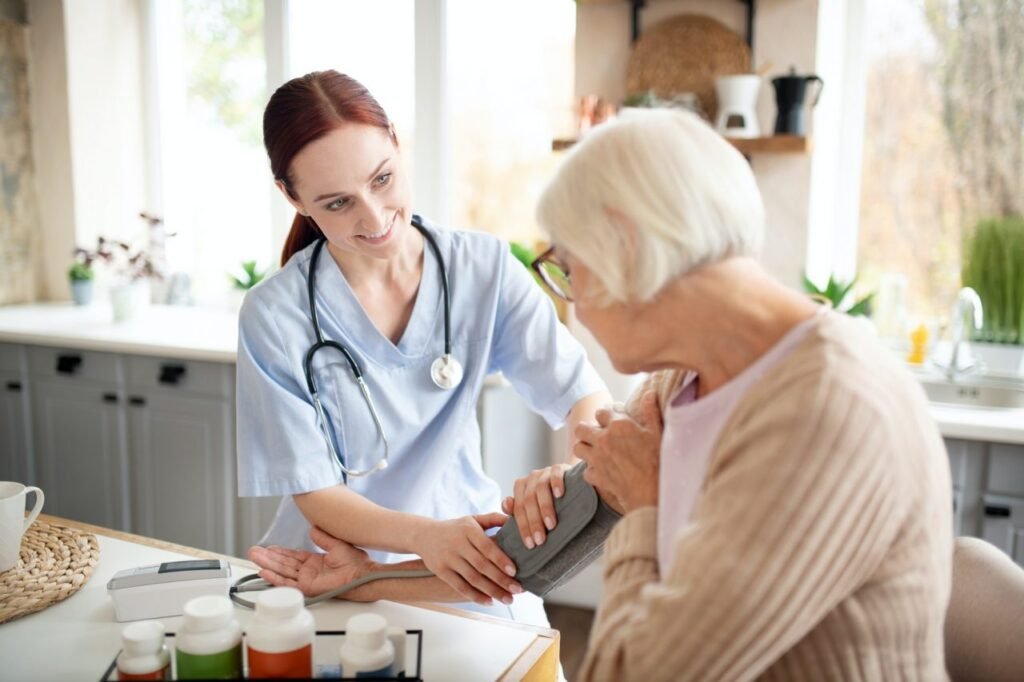 nurse wearing uniform measuring blood pressure for pensioner