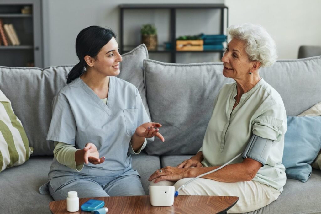 young nurse talking to senior woman in retirement home